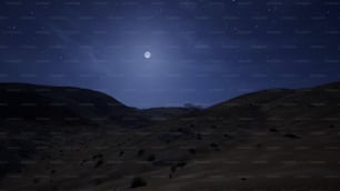 uma lua cheia é vista acima de uma paisagem desértica