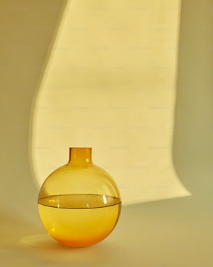 a yellow vase sitting on top of a white table