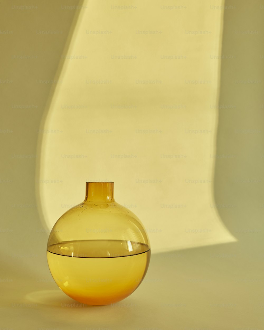 a yellow vase sitting on top of a white table