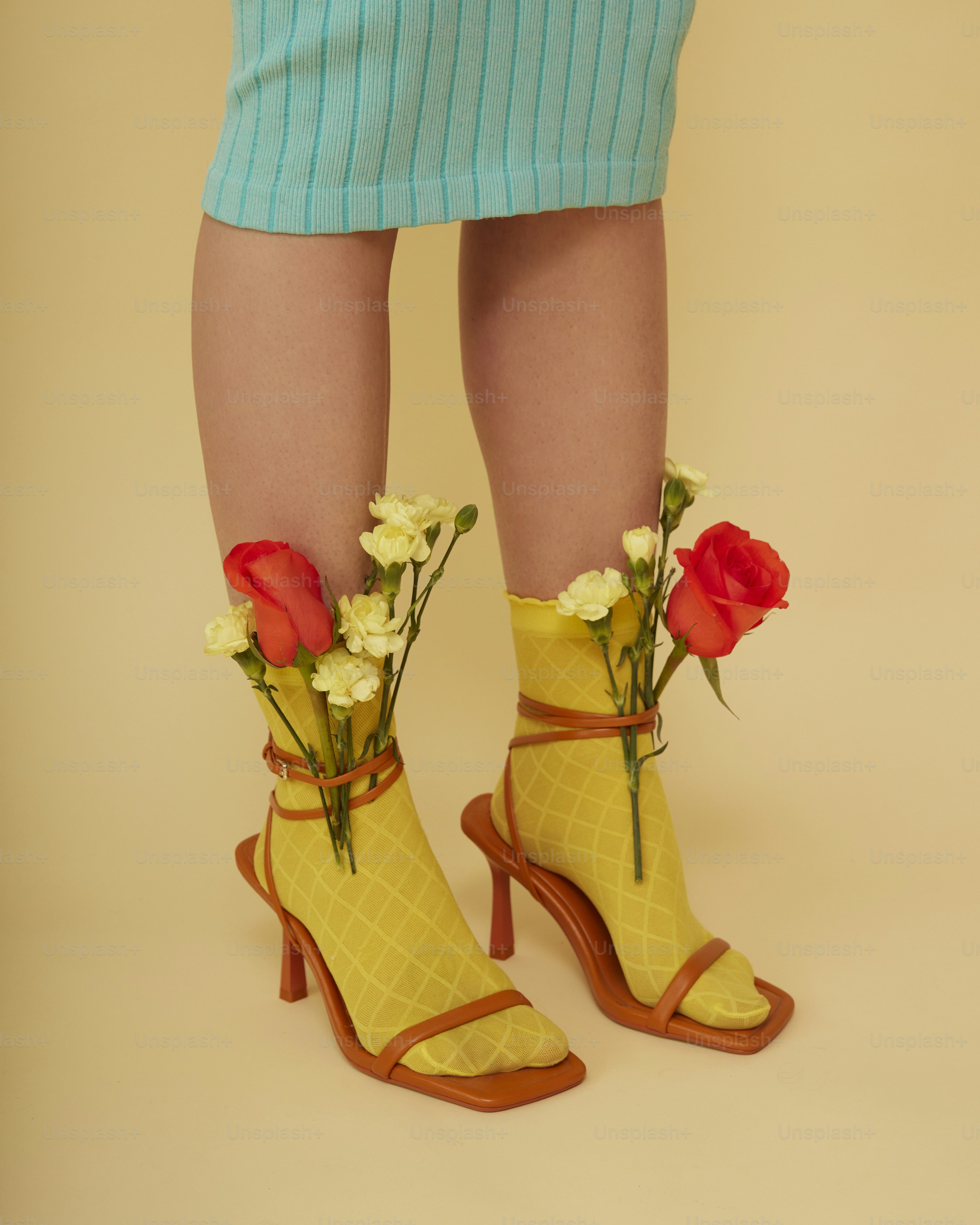 a woman's legs wearing yellow shoes with flowers in them