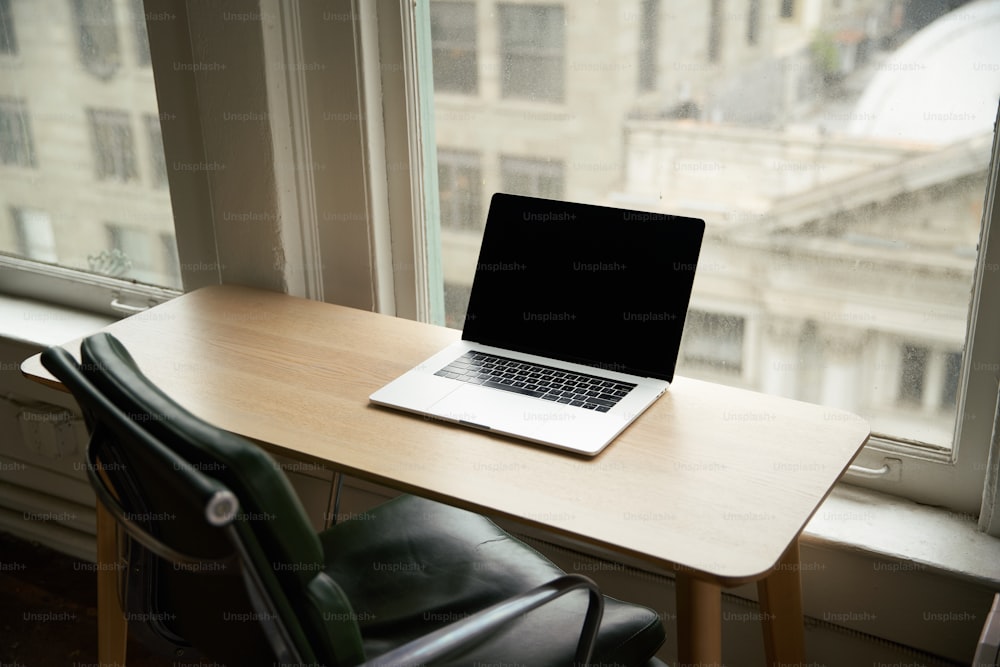 a laptop computer sitting on top of a wooden desk