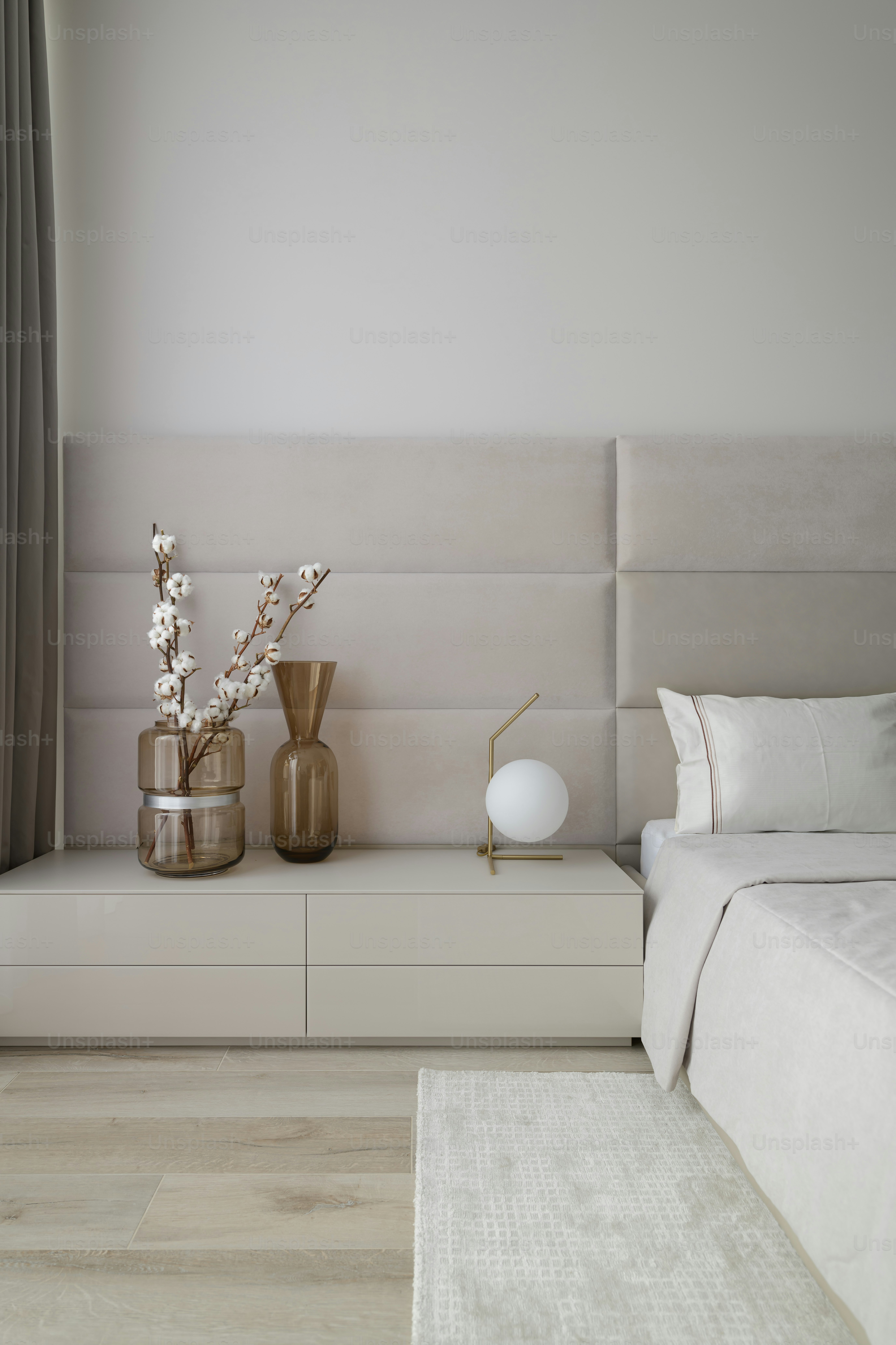 a bedroom with a bed, nightstand, and vase with flowers