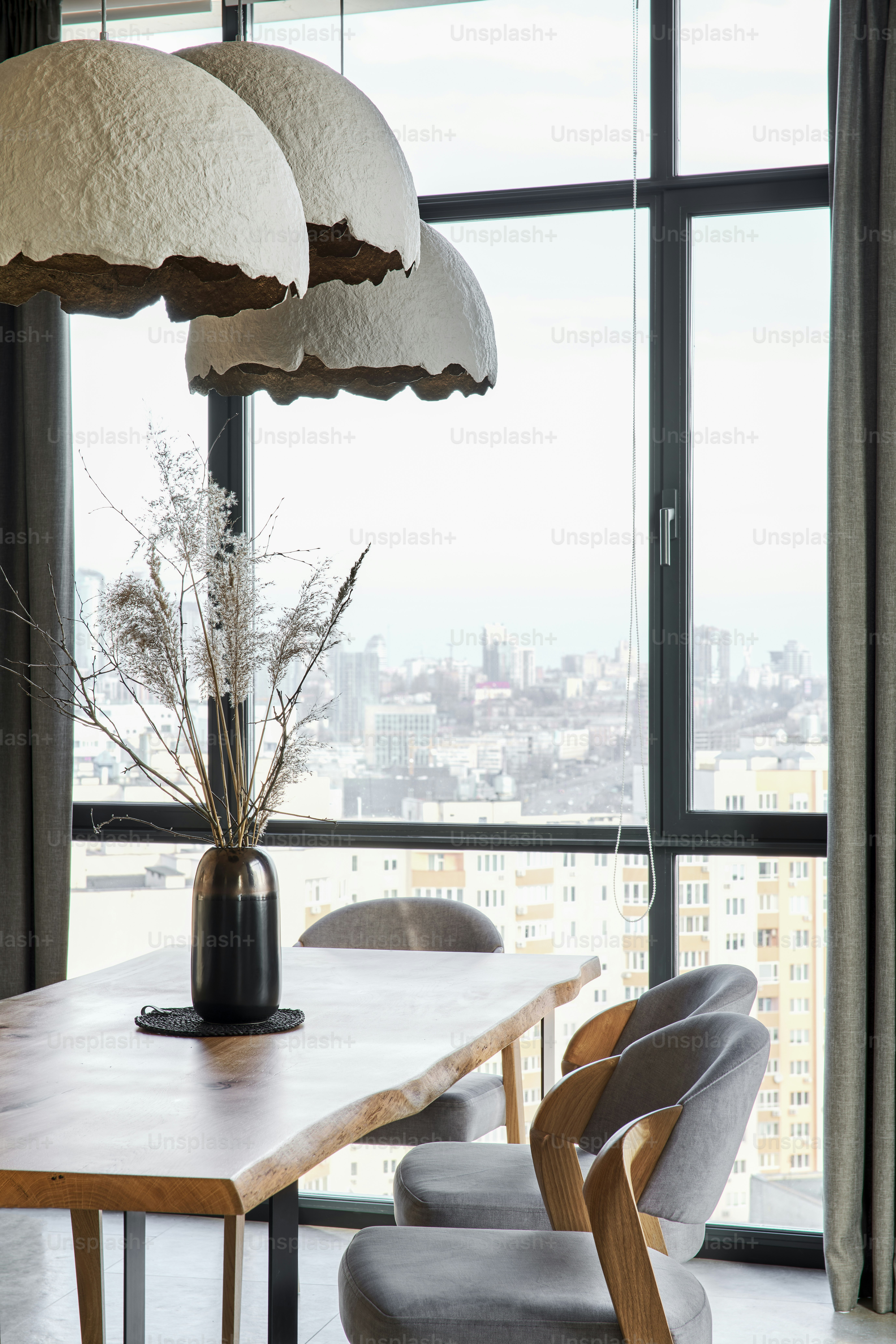 a dining room table with chairs and a large window