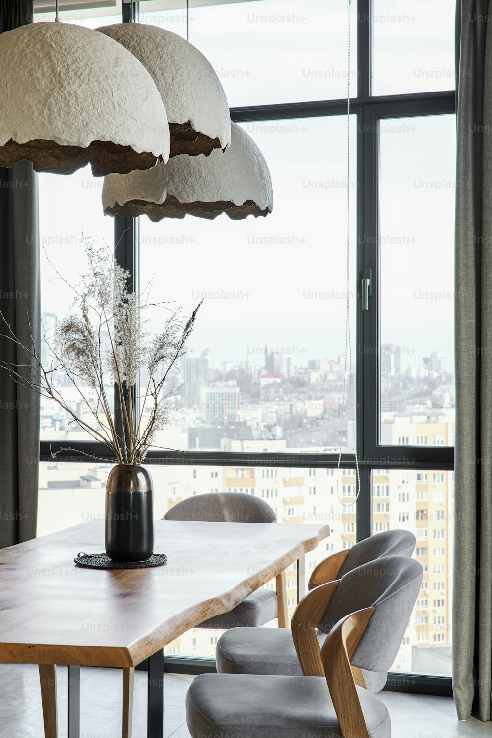 a dining room table with chairs and a large window