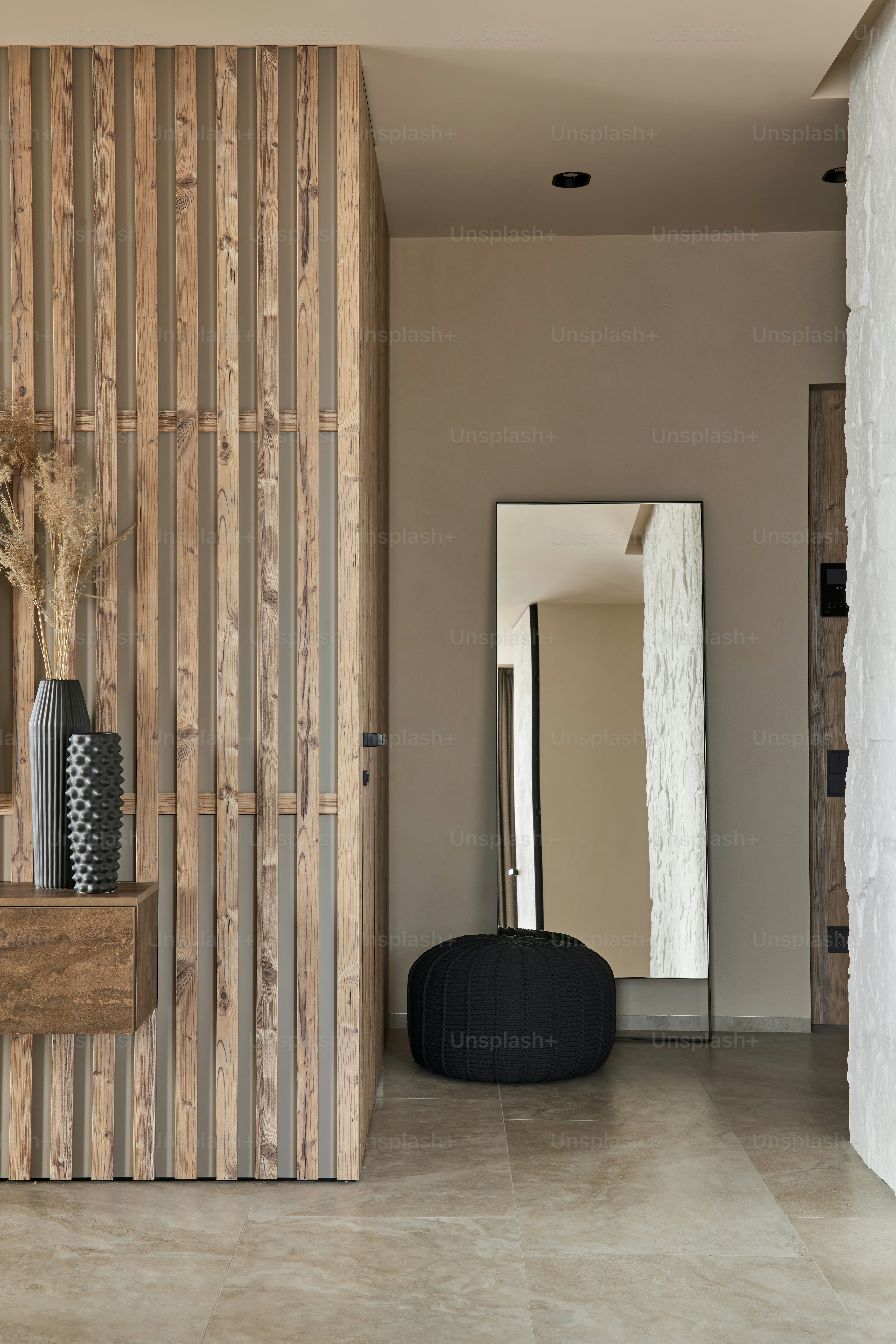 a room with a mirror, vases and a stool