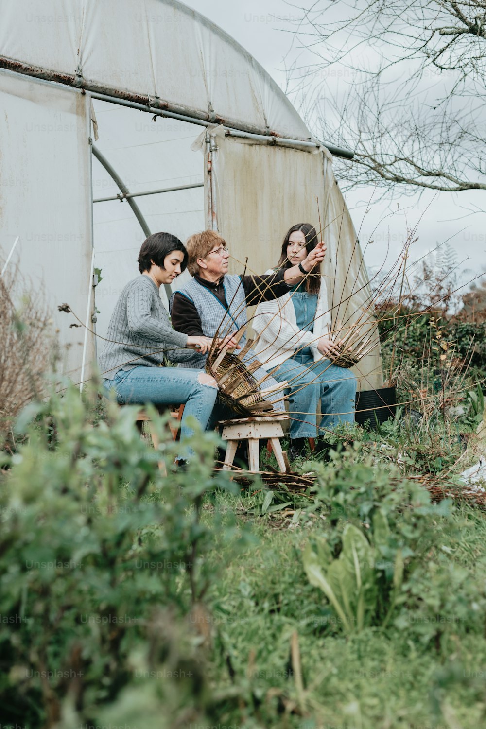 a group of people sitting on a bench in a field