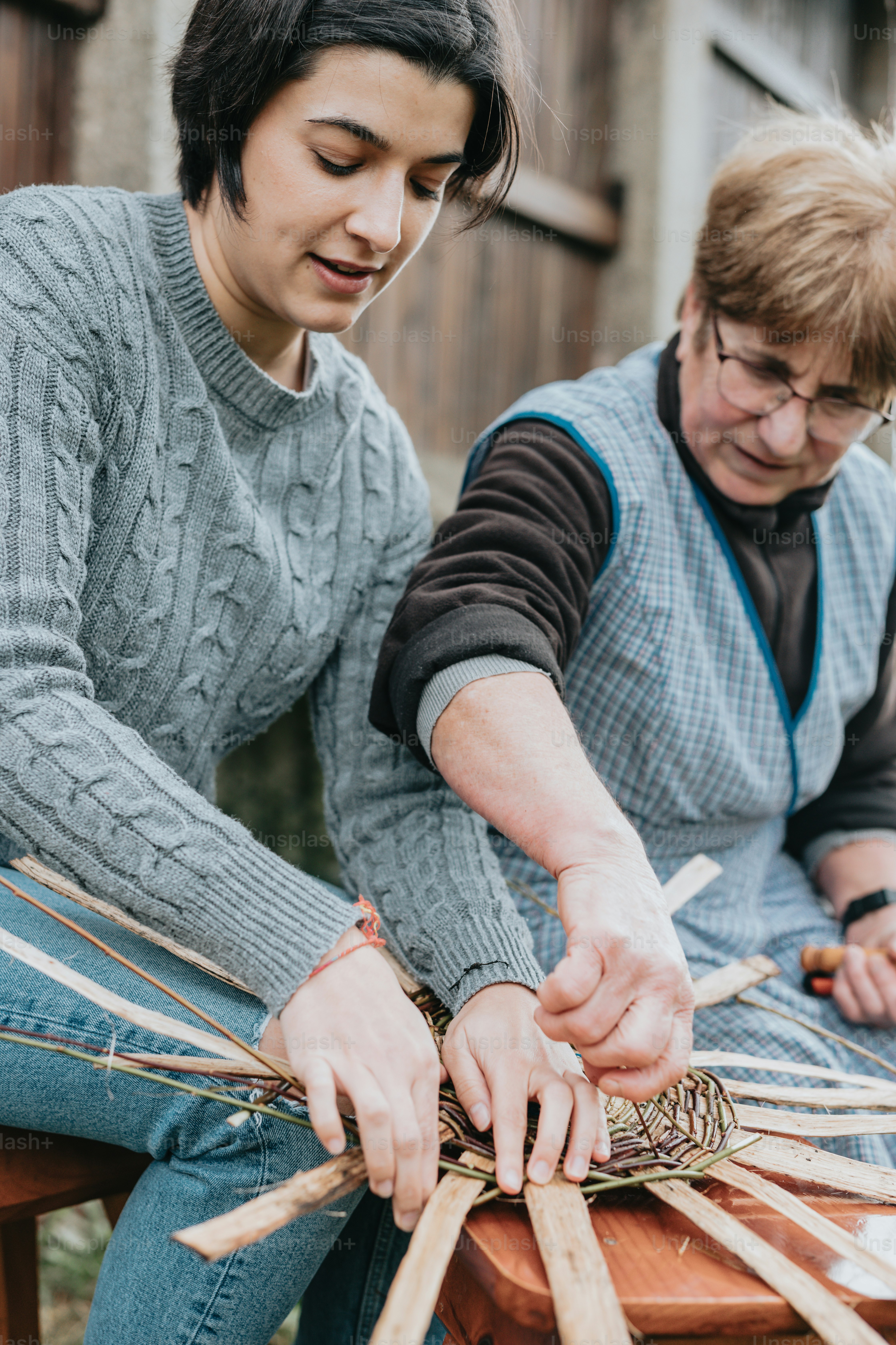 a man and a woman working on a piece of wood