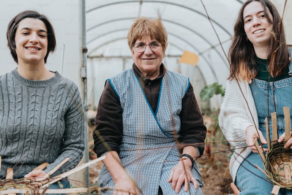 a group of women sitting next to each other in a greenhouse