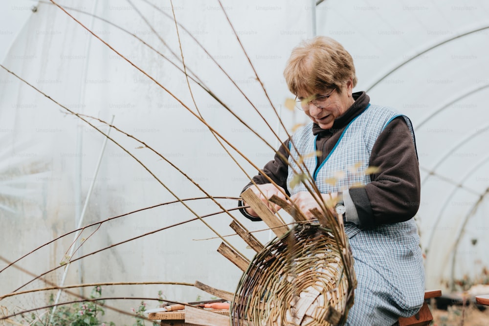 a woman working in a greenhouse holding a basket