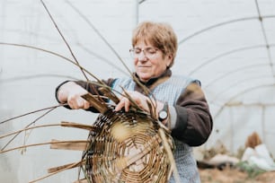 a woman holding a basket in a greenhouse