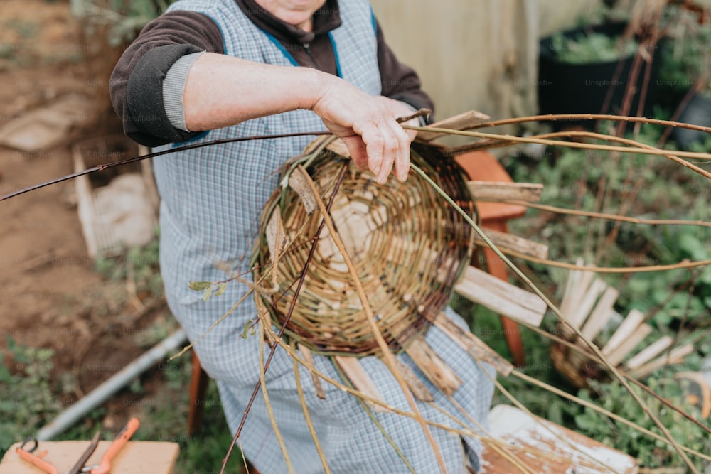 a man holding a basket full of grass