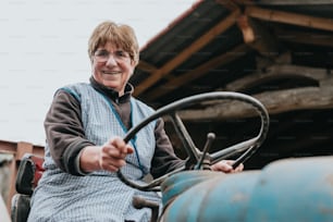 a woman sitting on top of a blue tractor