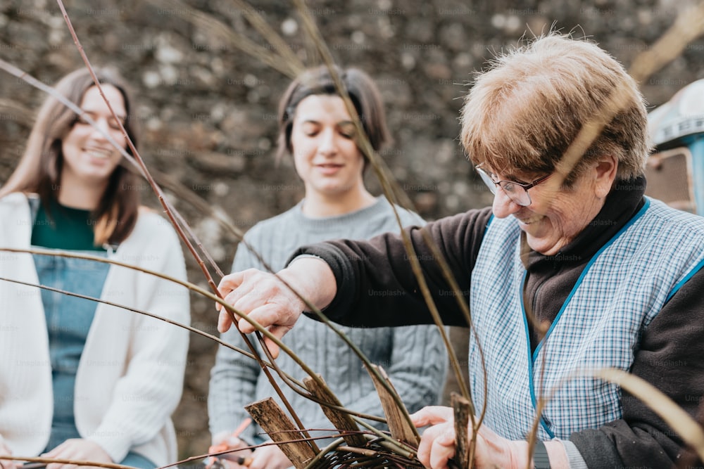 two women and a man are looking at plants