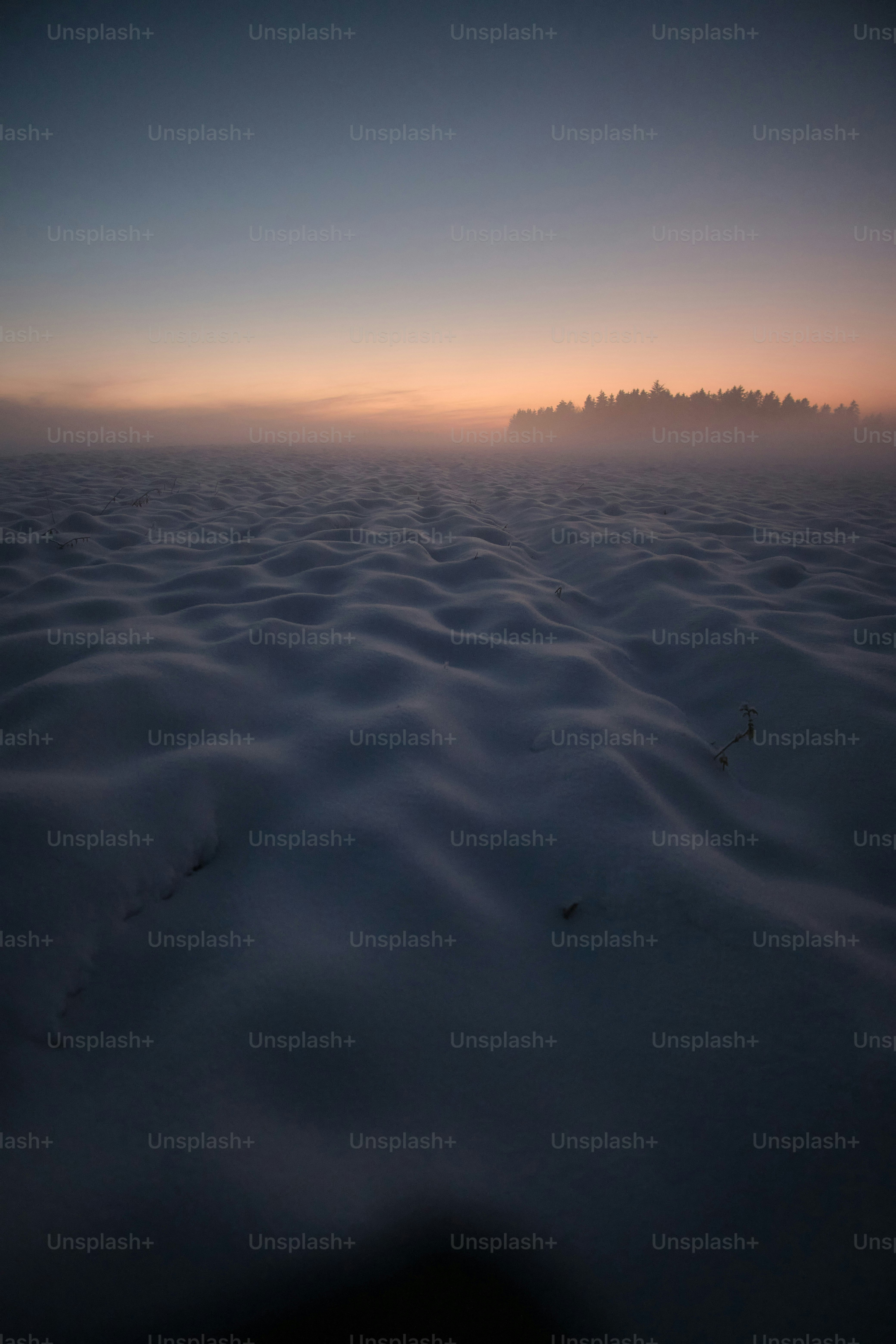 the sun is setting over a vast expanse of snow