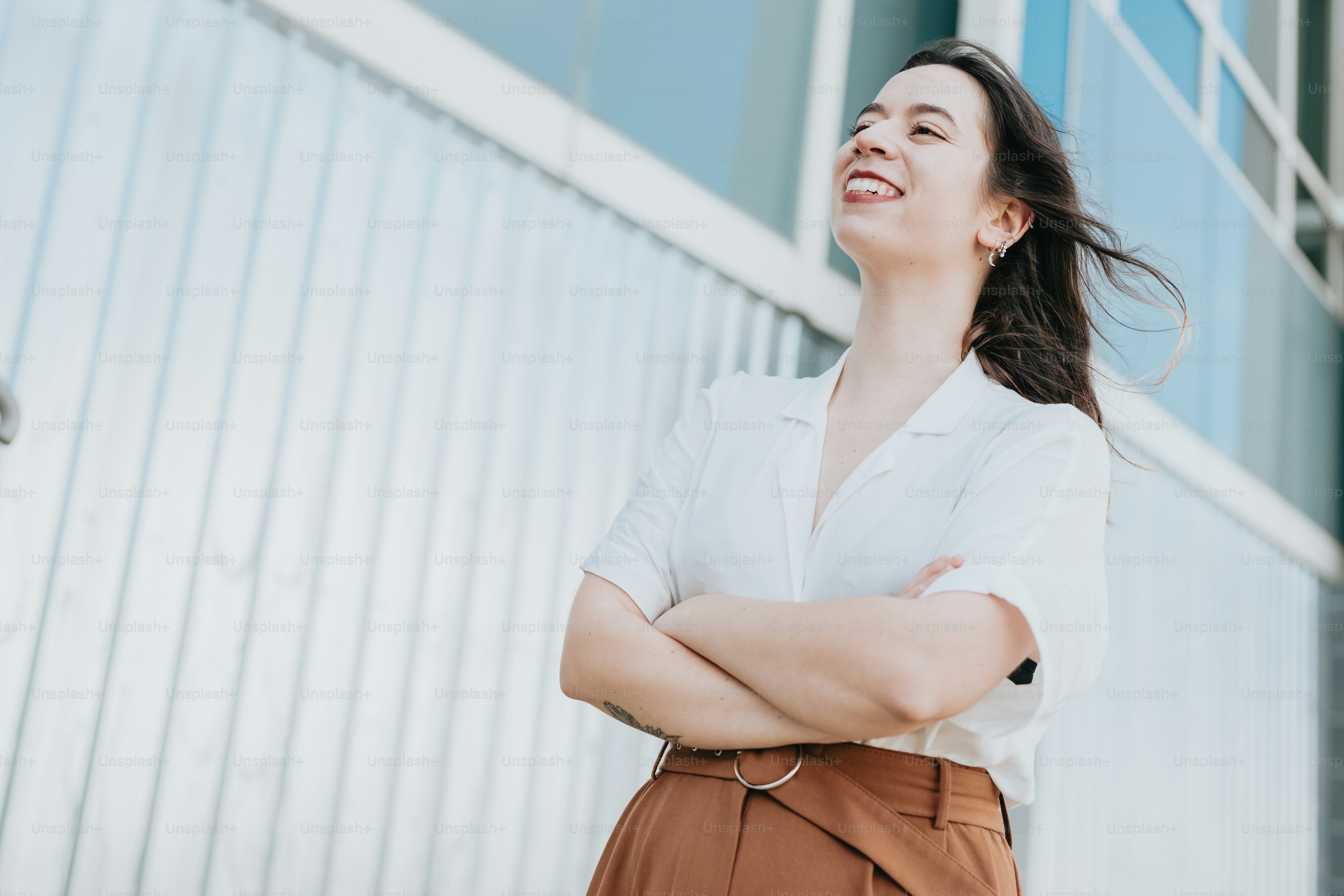 a woman standing with her arms crossed in front of a building