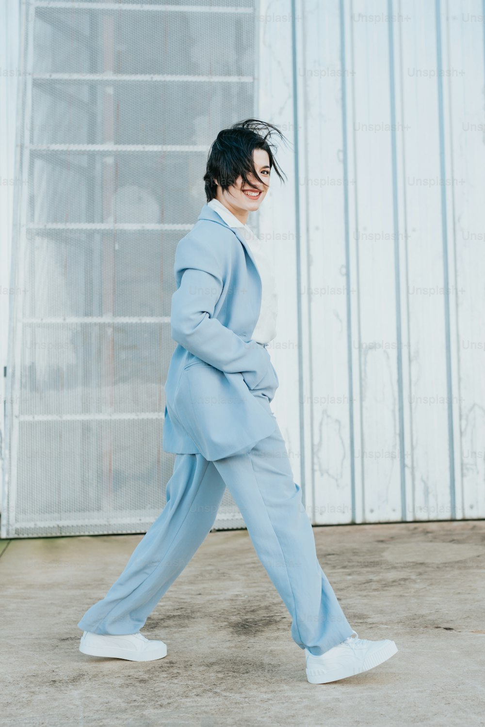 a person in a blue suit and white sneakers