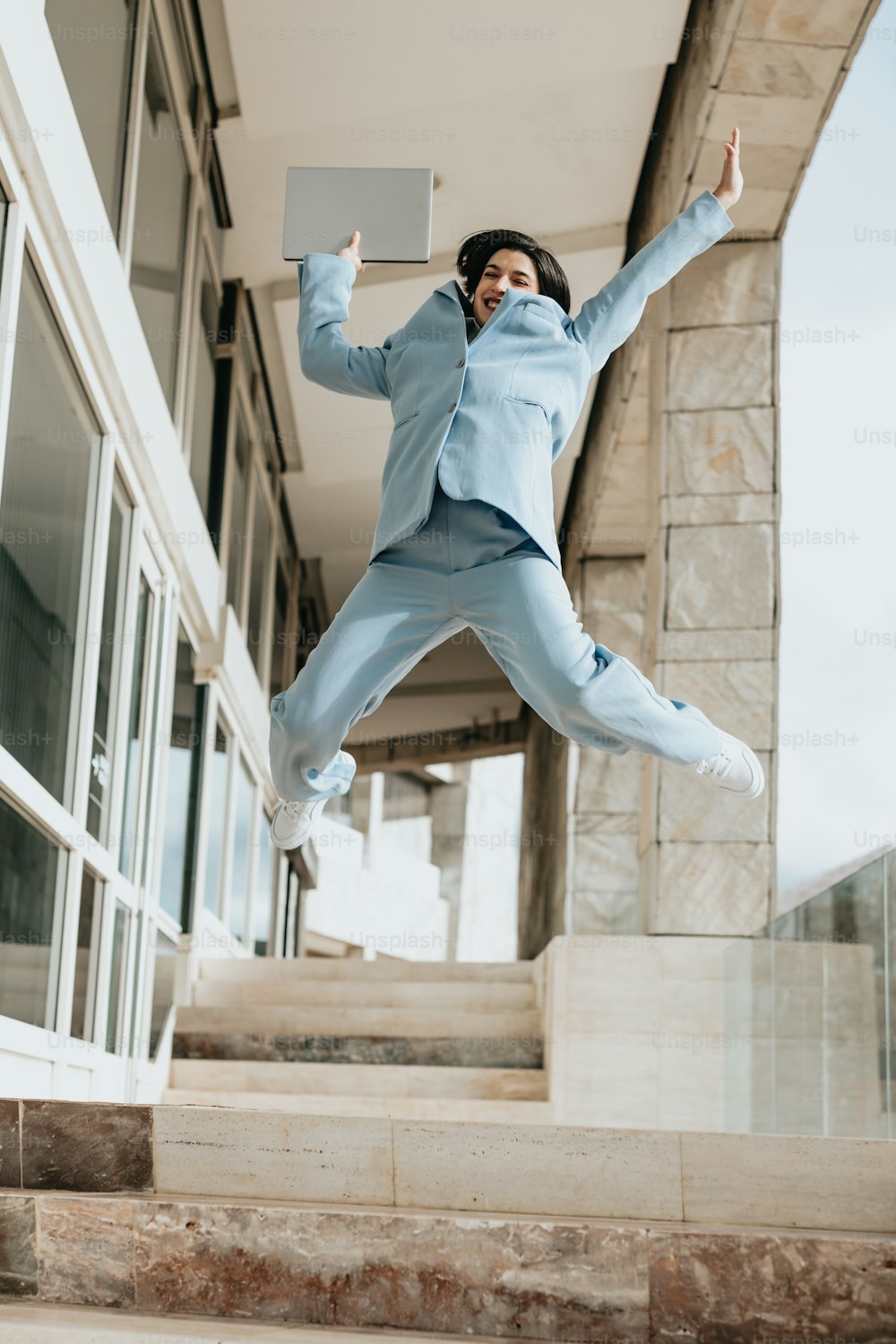 Un hombre con un traje azul saltando en el aire