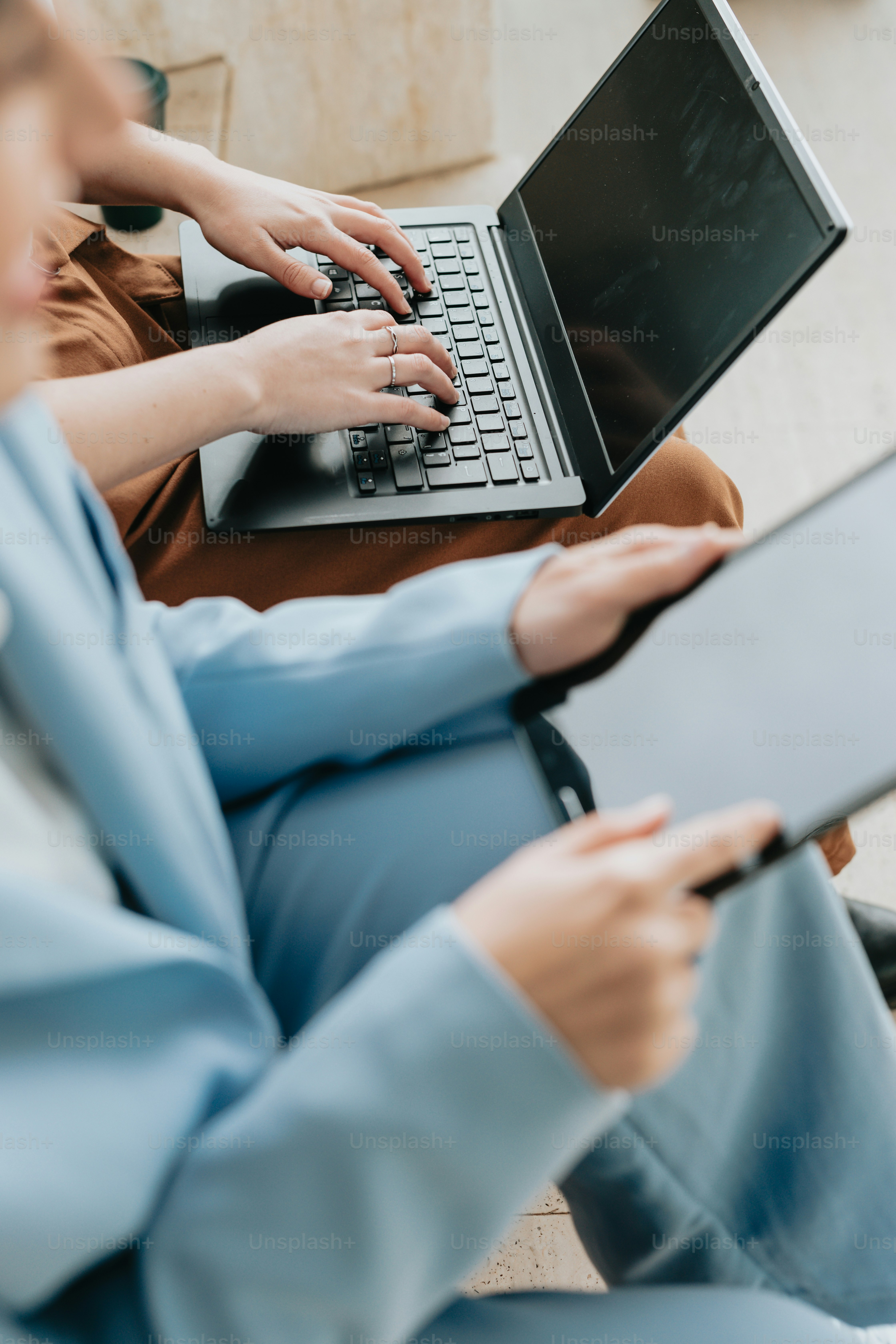 Una mujer sentada en un sofá usando una computadora portátil
