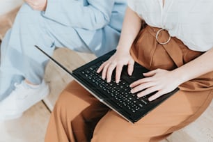 una donna seduta sul pavimento usando un computer portatile