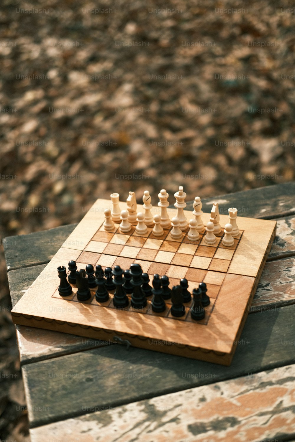 ein hölzernes Schachbrett, das auf einer Holzbank sitzt