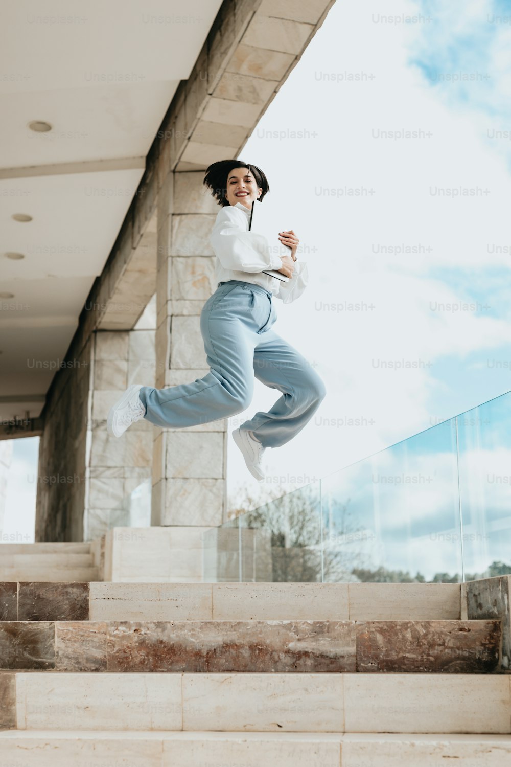 a woman jumping up and down some stairs