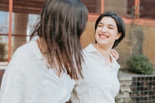 a woman standing next to another woman in a white shirt