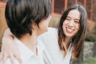 Una mujer está sonriendo y hablando con otra mujer