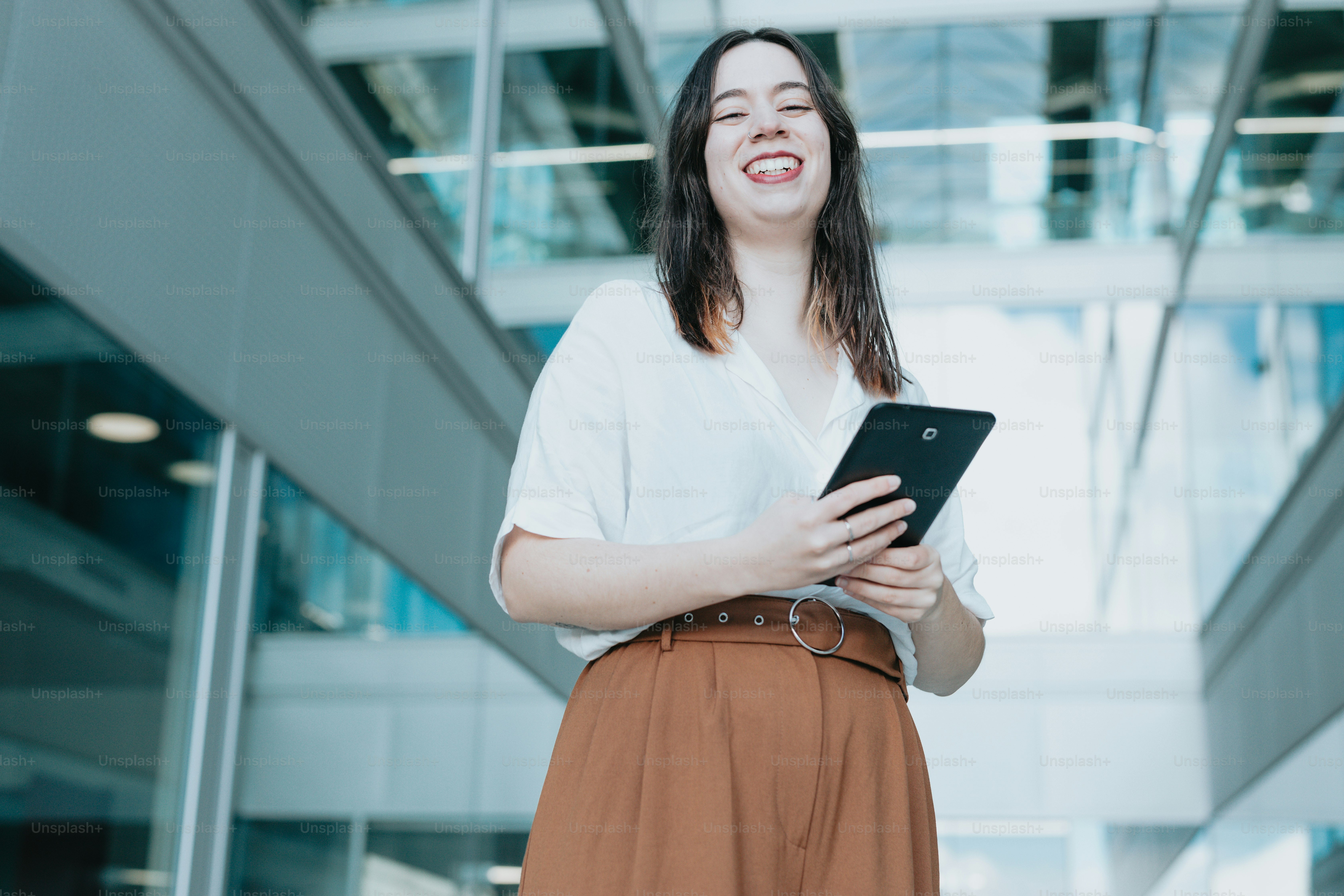a woman standing in front of a building holding a tablet