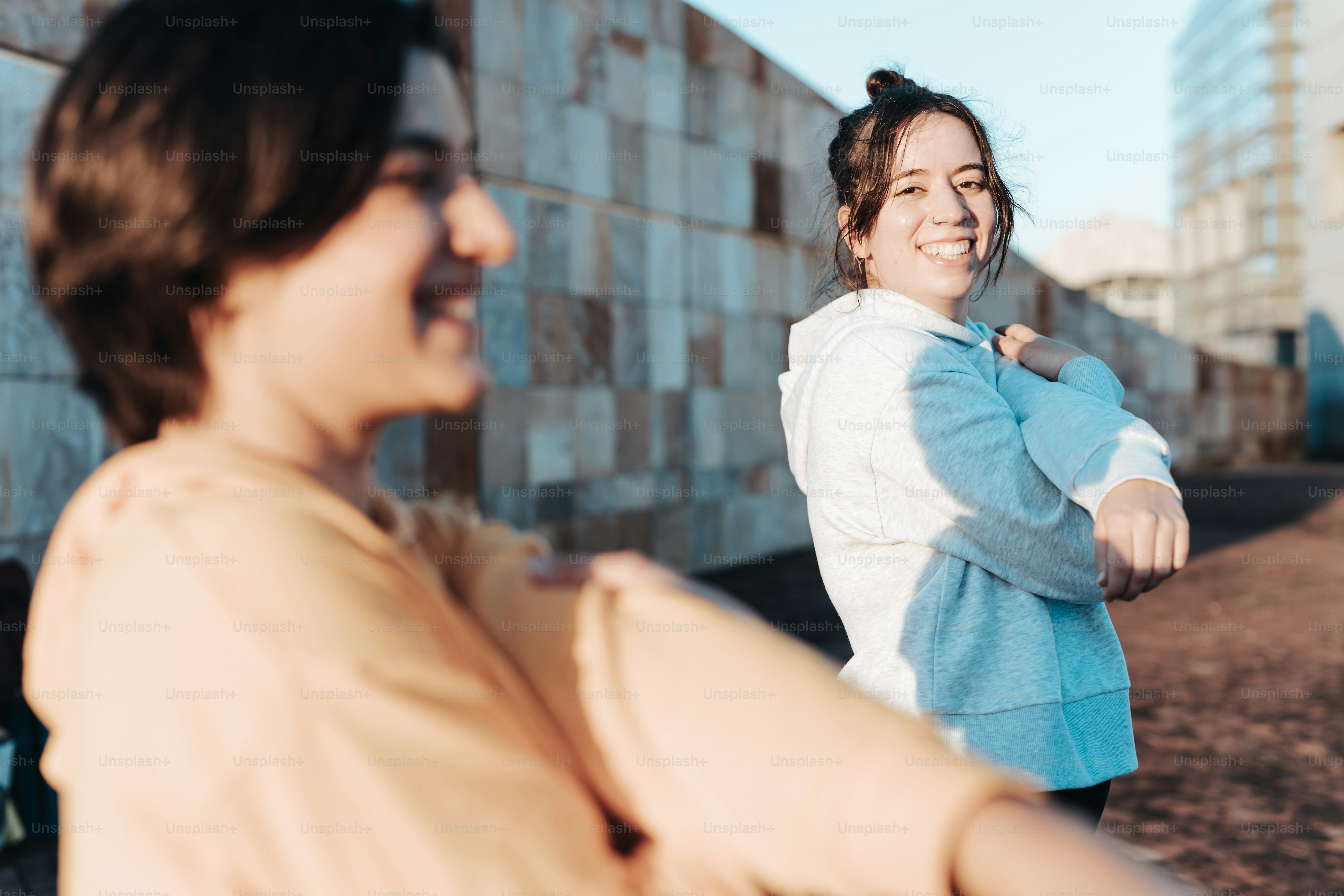 a woman standing next to another woman near a wall