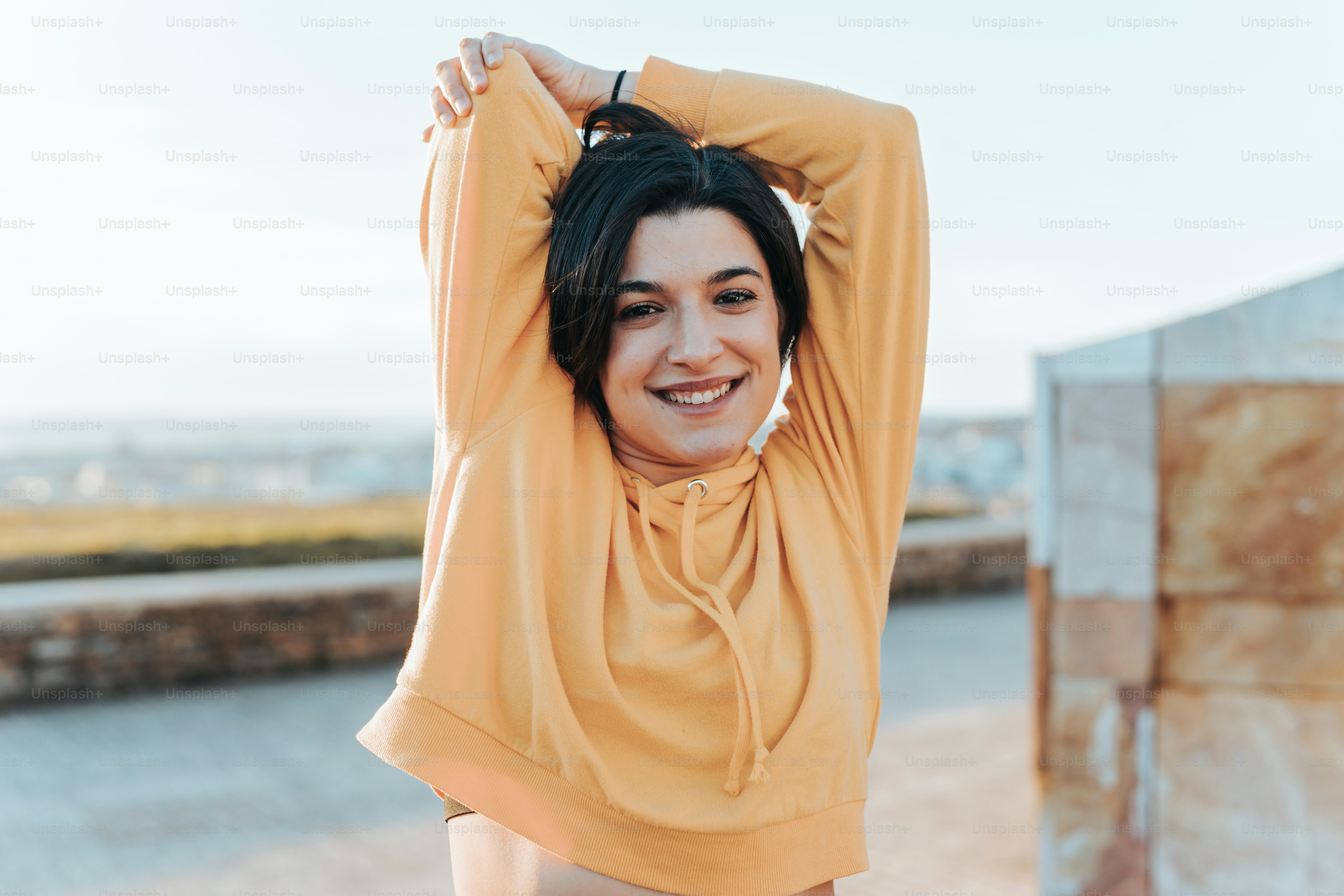 a woman in a yellow top is posing for a picture