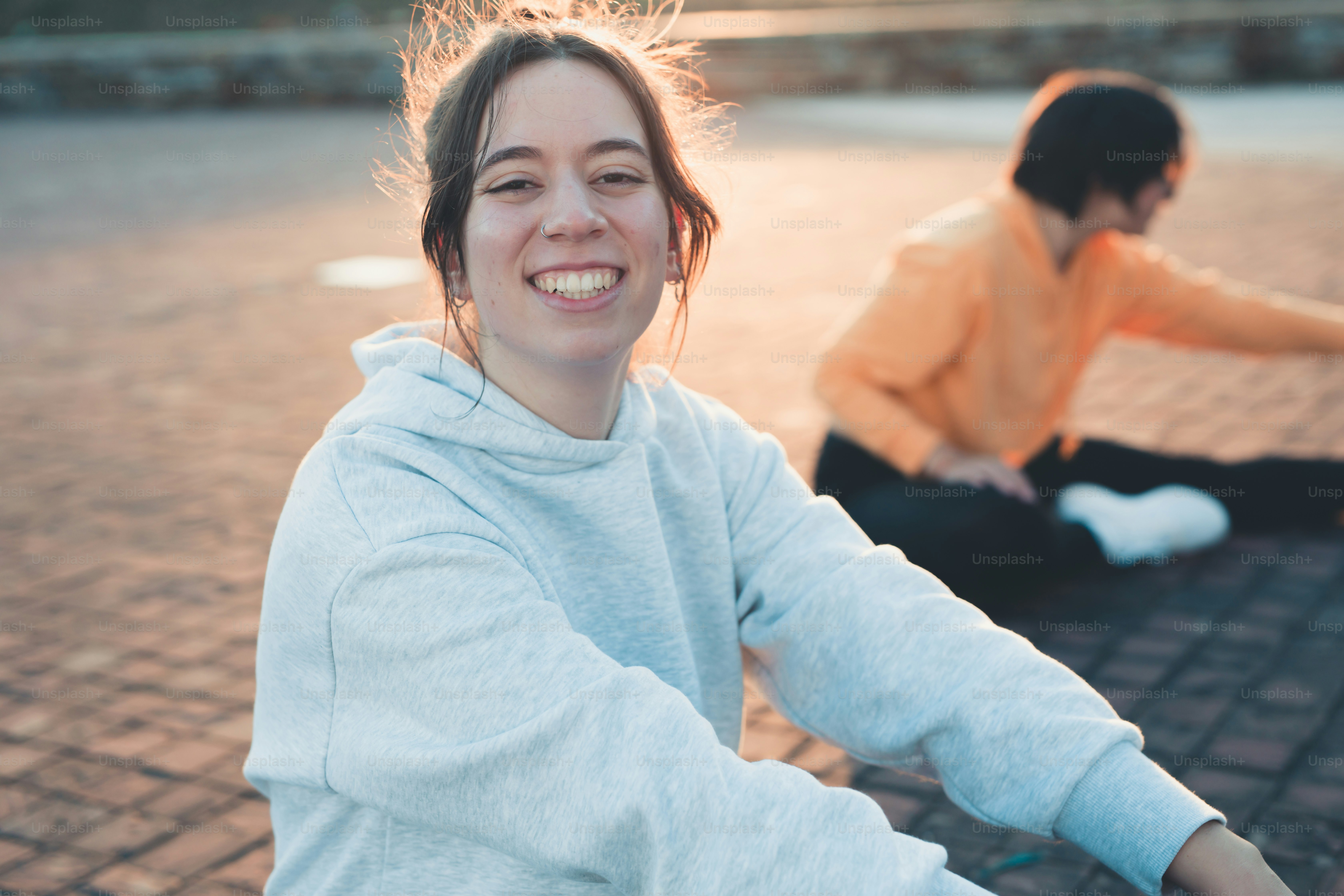 a woman sitting on the ground with a smile on her face