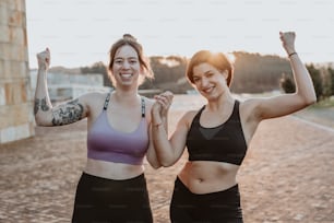 two women standing next to each other with their arms in the air