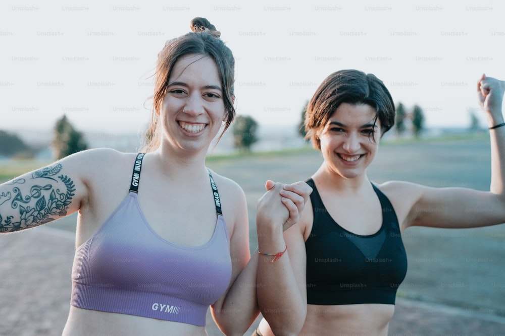 two women standing next to each other in sports bras