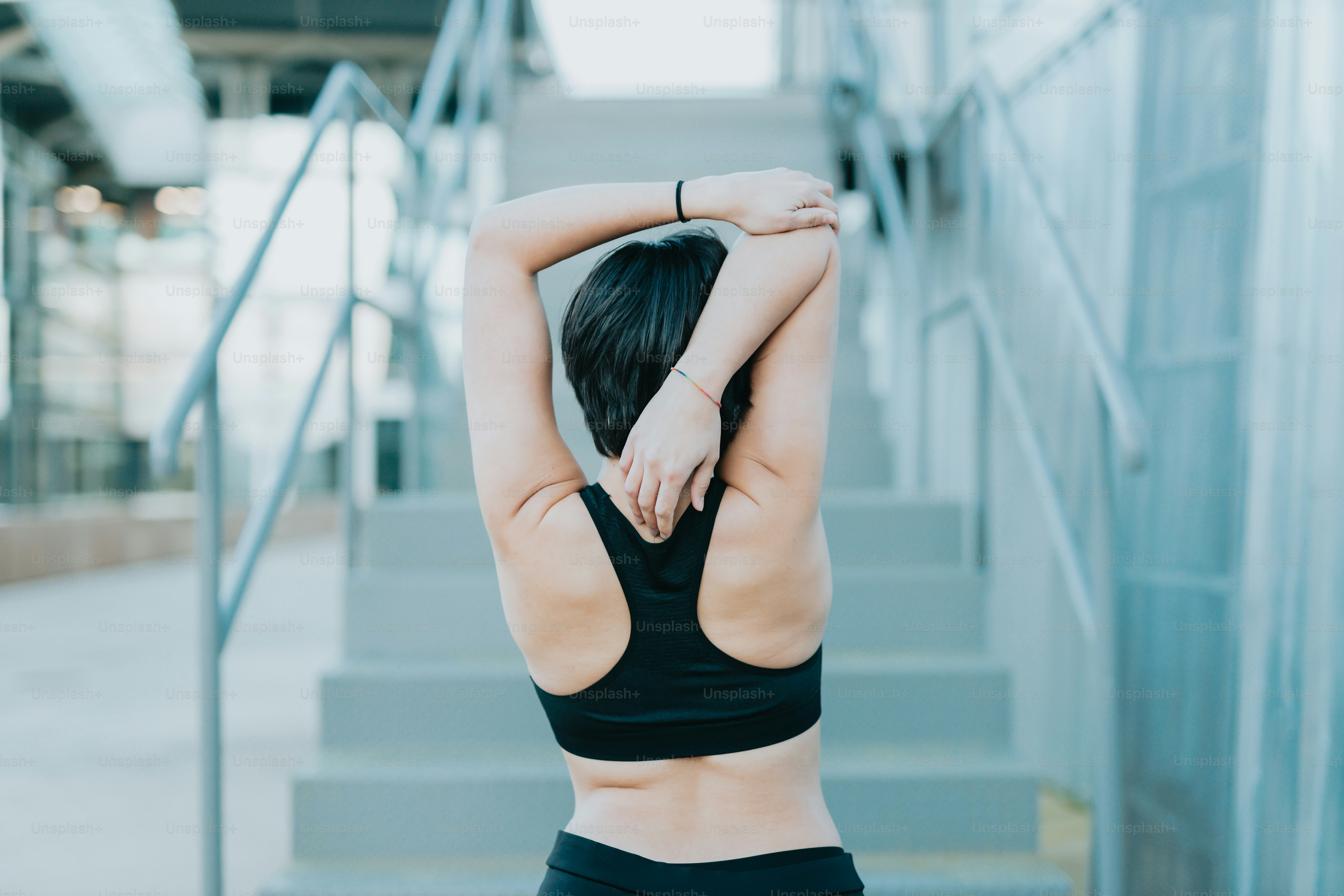 a woman in a black sports bra top standing on stairs