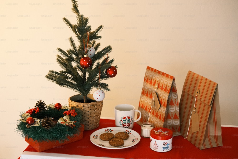 a table topped with a christmas tree next to a plate of cookies