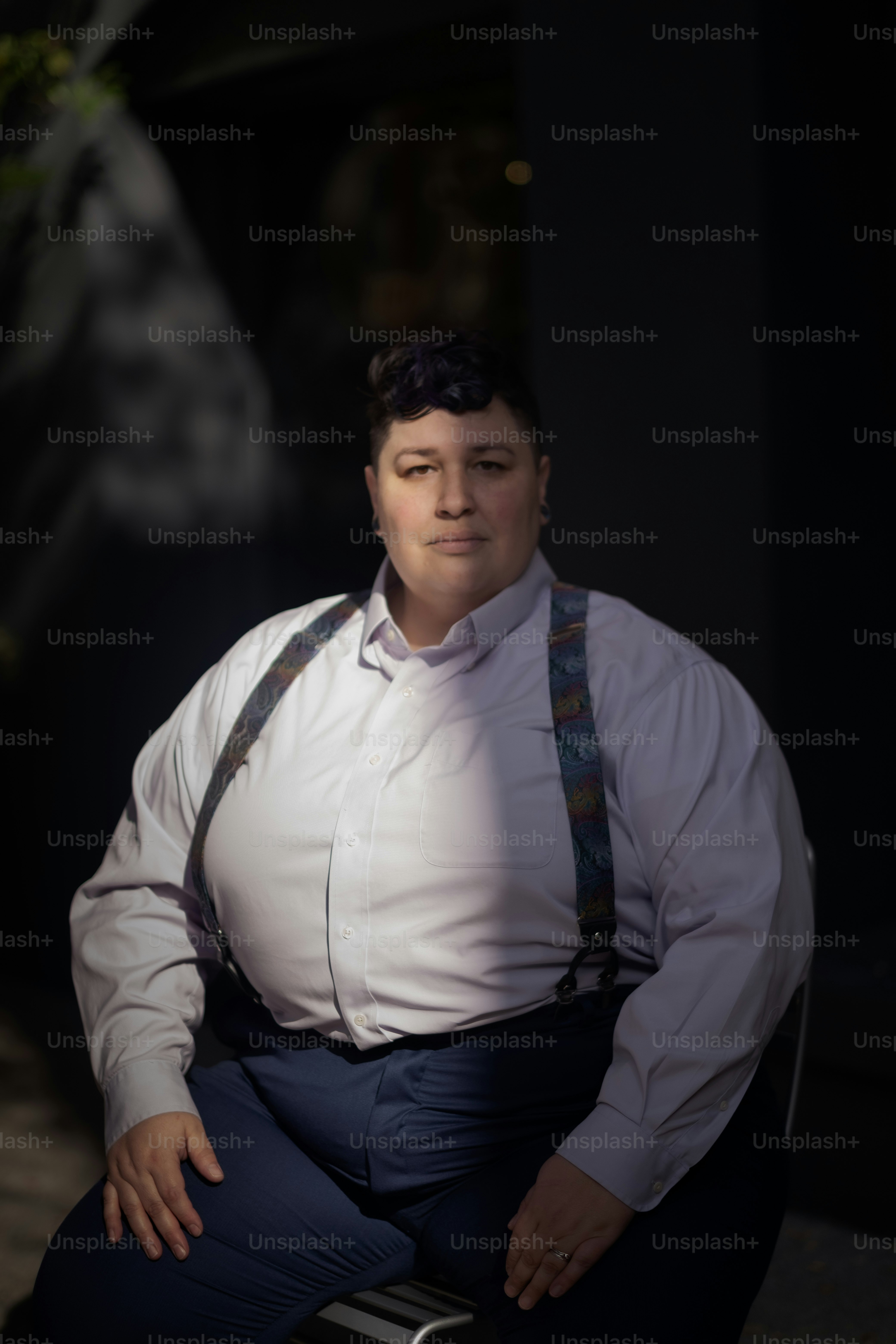 Un hombre con tirantes y una camisa blanca