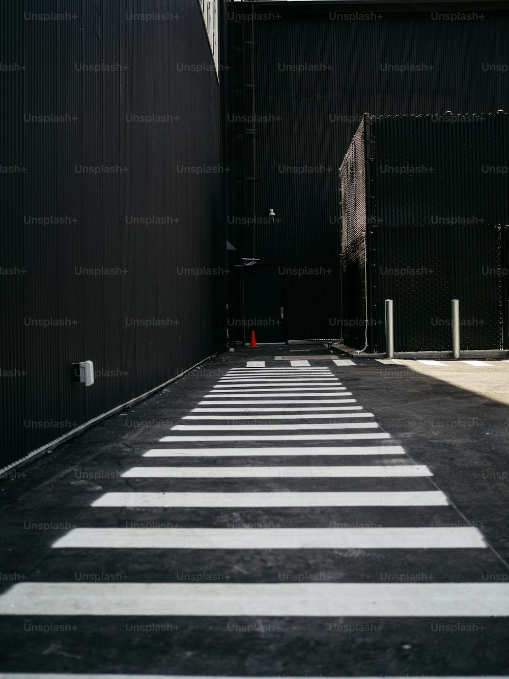 an empty parking lot with a black building in the background