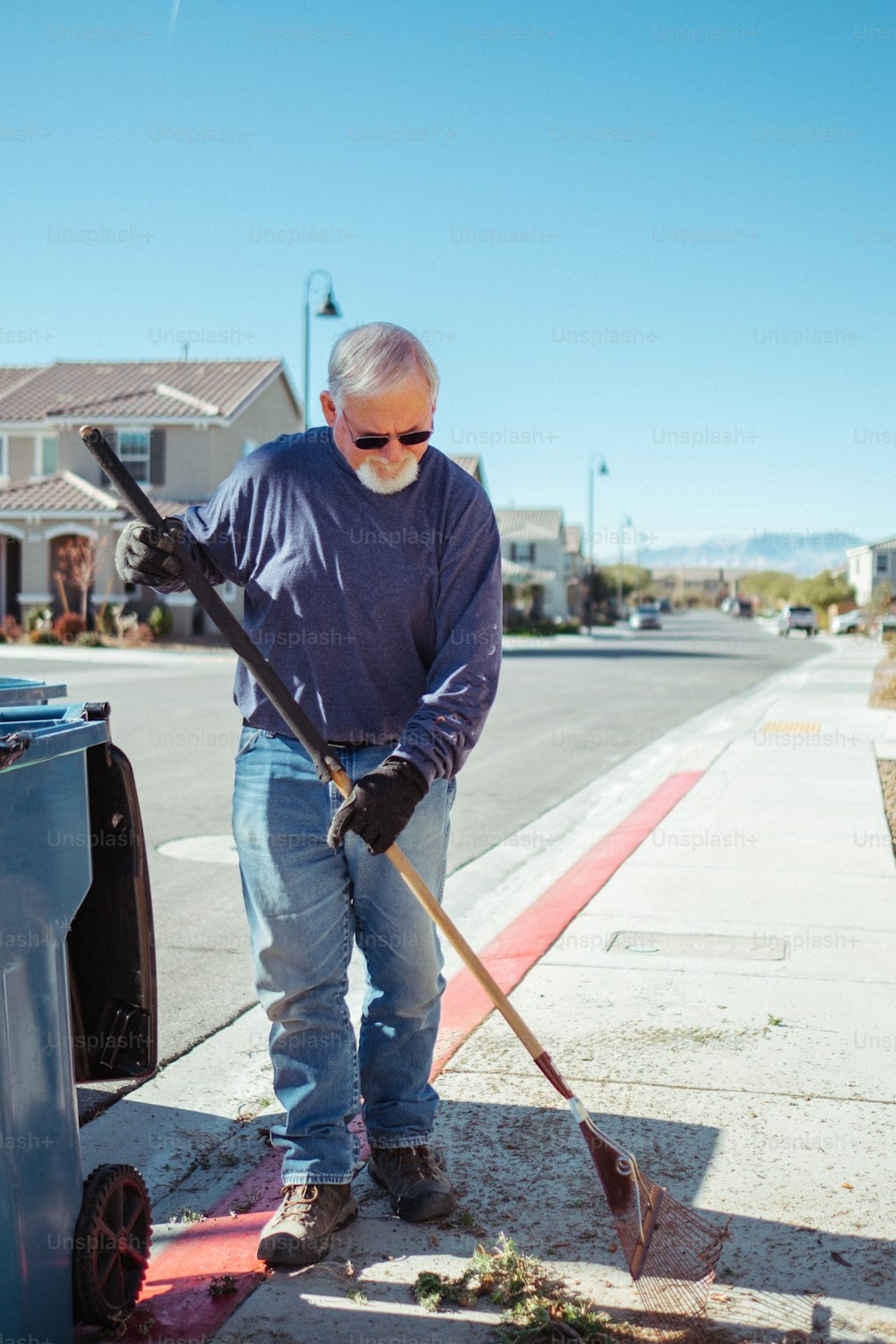 a man with a shovel is cleaning the sidewalk