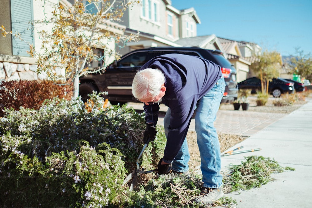 an older man is digging in a garden