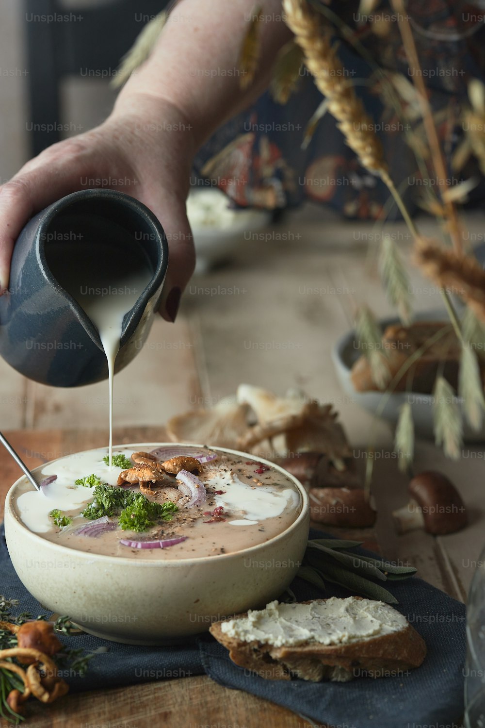 a person pours milk into a bowl of soup