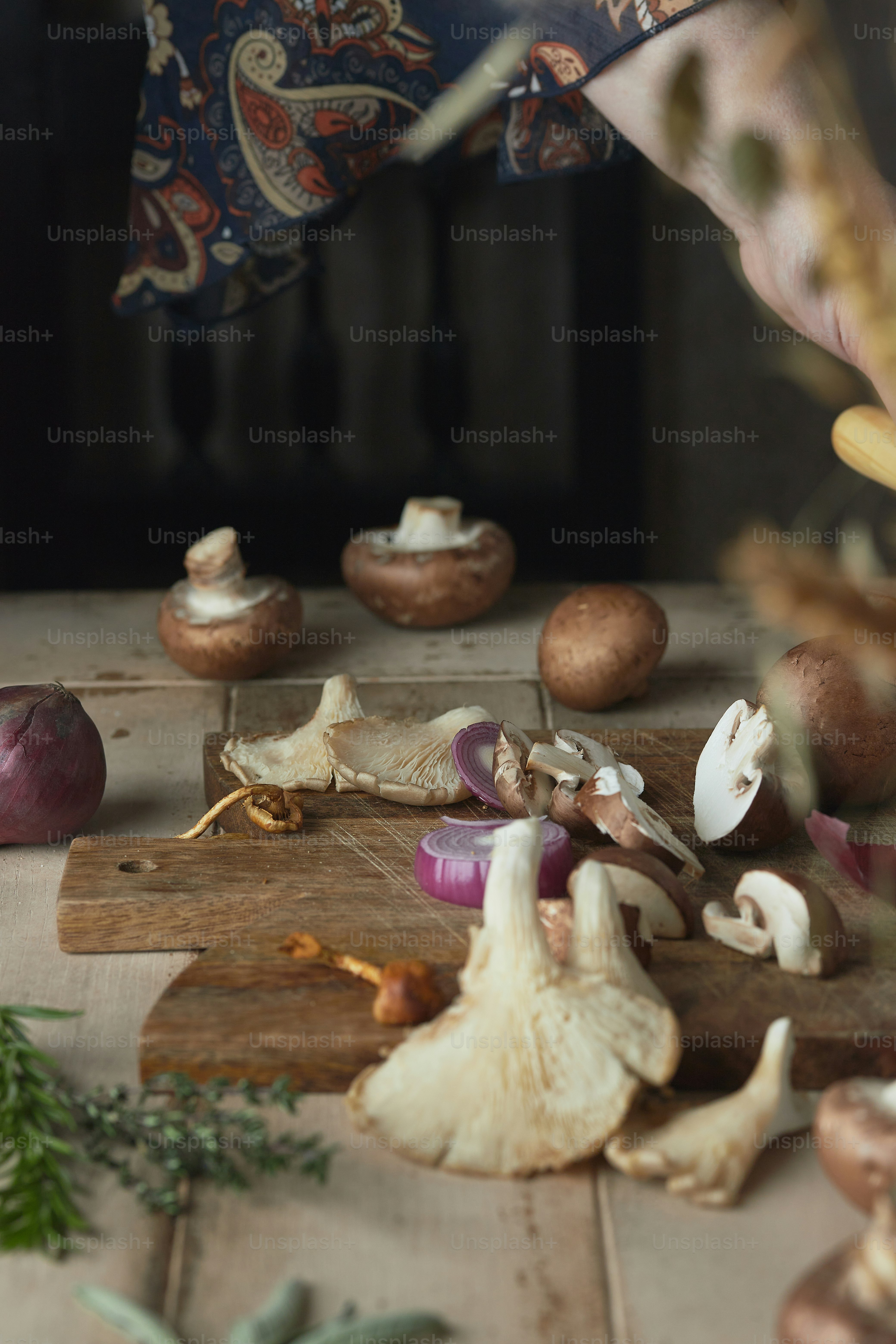 a person chopping mushrooms on a cutting board
