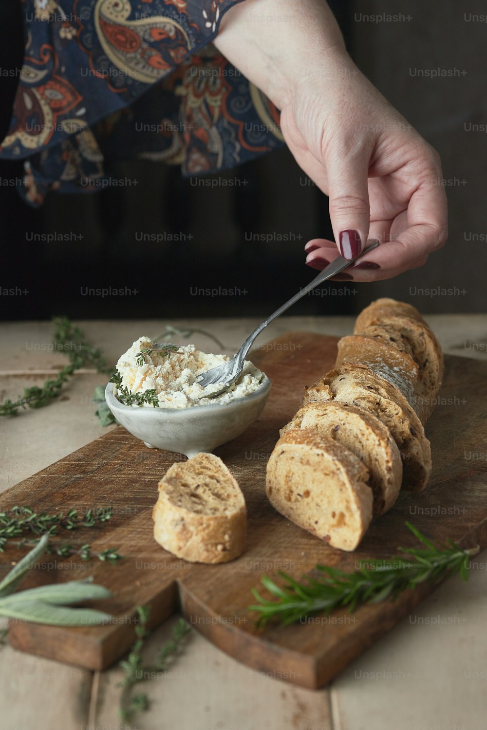 a person cutting bread with a knife on a cutting board