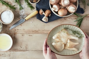 a person holding a plate with mushrooms on it