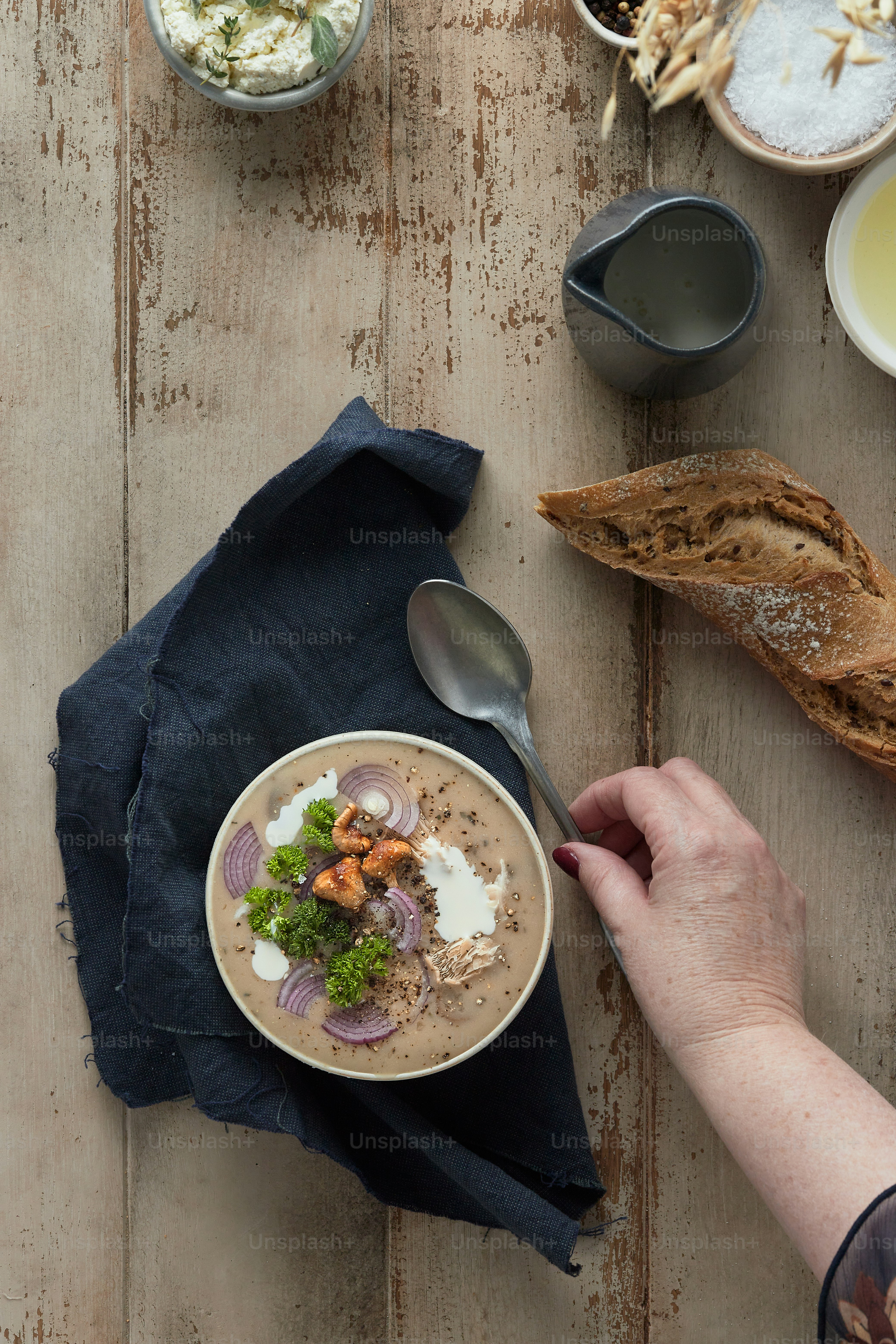 a person holding a spoon over a bowl of food