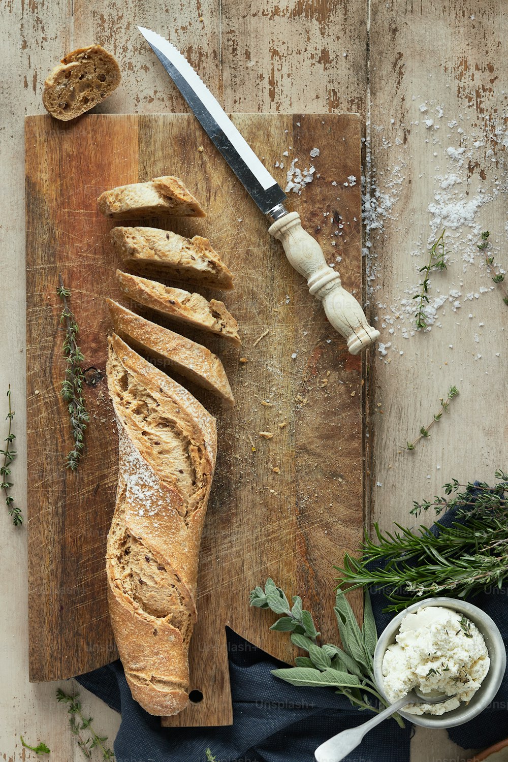 Ein Laib Brot auf einem Schneidebrett neben einem Messer