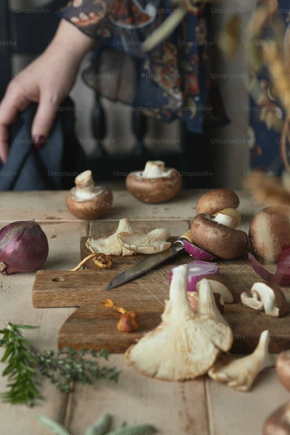 a person chopping mushrooms on a cutting board