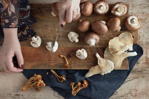 a person cutting mushrooms on a cutting board