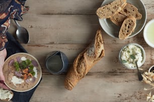 a table topped with bowls of food and bread