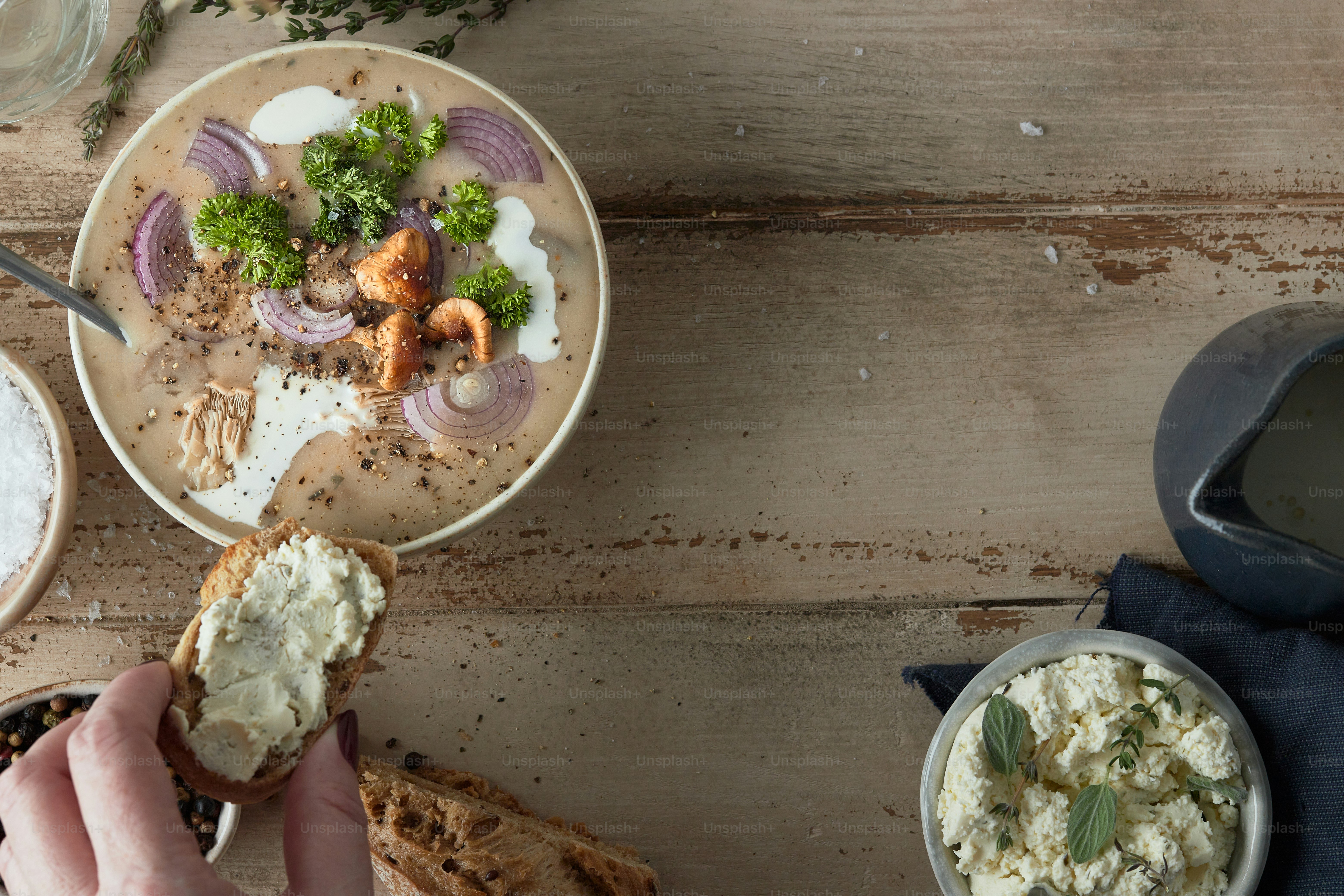 eine Person, die ein Stück Brot über einer Schüssel mit Essen hält