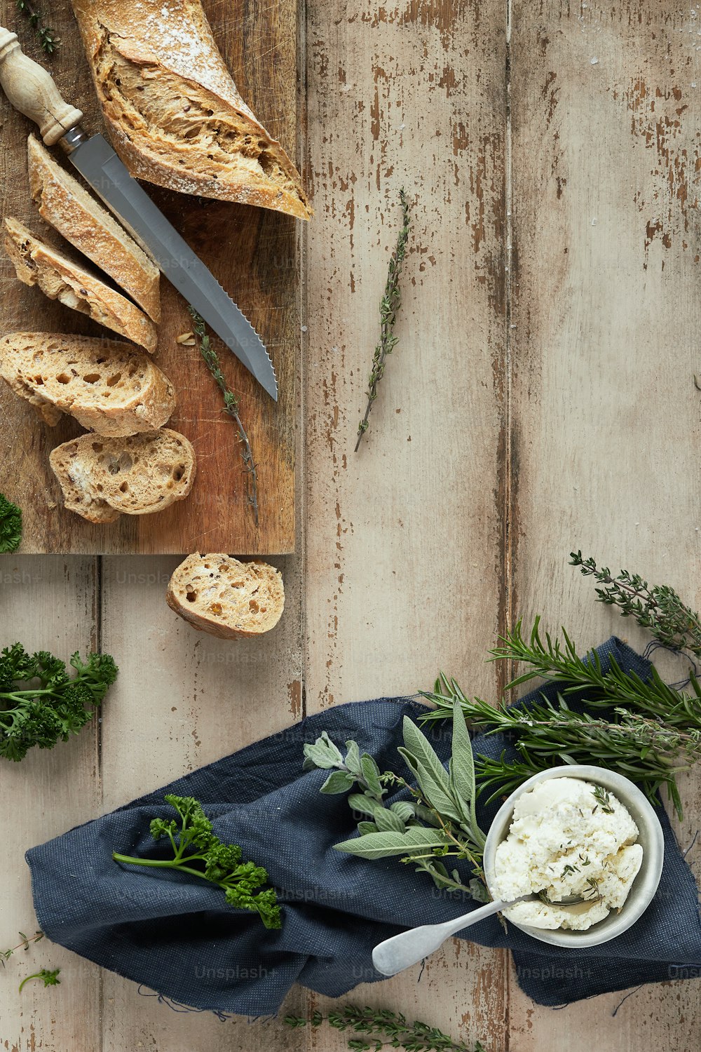 ein Tisch mit Brot und Gemüse neben einem Messer